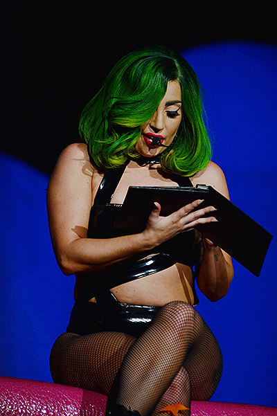 Lady Gaga takes time out to honor a fans devotion by reading his photo album dedicated to her onstage  during the Los Angeles date of her ArtPop Tour at the Staples Center in Los Angeles, CA