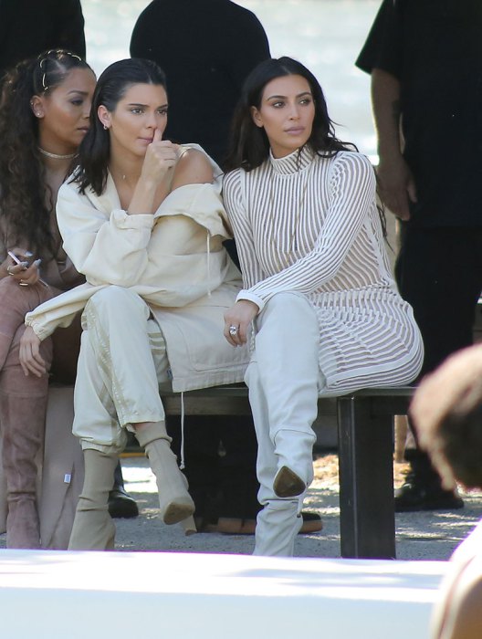 Kim Kardashian and Kendall Jenner watch the Yeezy season 4 show in a park with other celebs and sisters as they watch the runway models