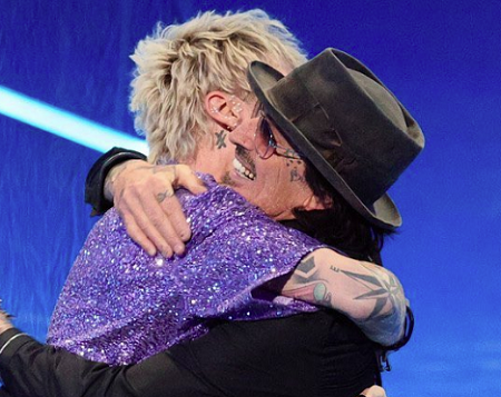 Mötley Crüe выпустили ремастер ранней версии Take Me to the Top - 2 Томми Ли в чёрной шляпе обнимает музыканта Machine Gun Kelly в блестящем фиолетовом костюме