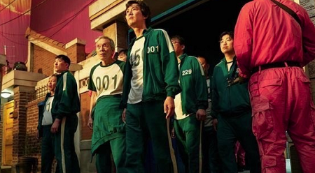 От «Игры в кальмара» к Tantara: Netflix представил новые проекты на юбилее в Сеуле - 1 Персонажи первого сезона «Игры в кальмара» в зелёных костюмах стоят на игровой площадке