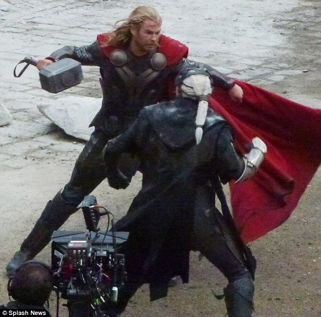 It's hammer time: Chris Hemsworth brandishes a hige metal hammer as he fights it out with co-star Christopher Eccleston on set in London this week