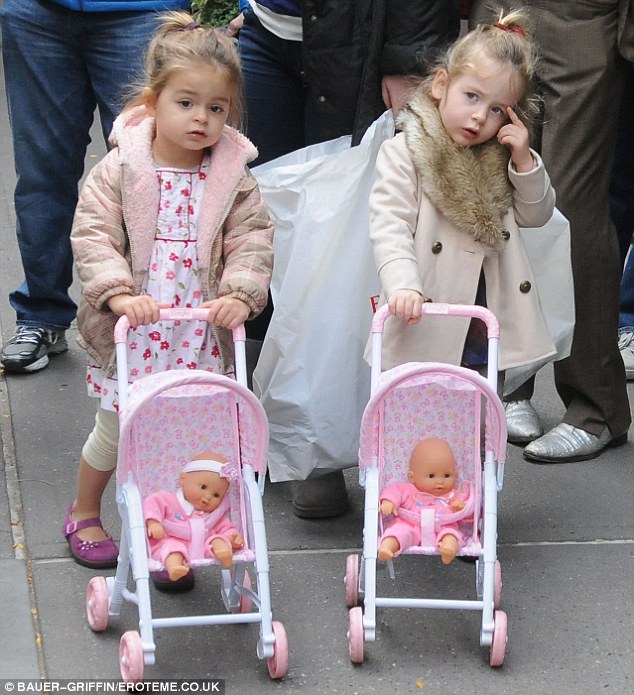 Baby love: The pretty twins pushed their dolls in matching pink patterned strollers 
