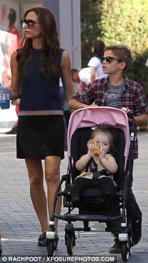 Swapping roles: Victoria Beckham sipped a blue Slushy while Romeo pushed Harper's stroller on a recent shopping trip