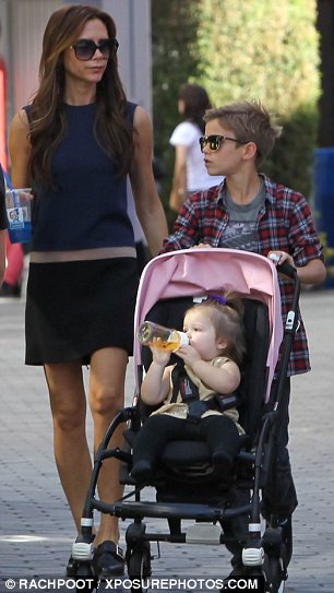 Swapping roles: Victoria Beckham sipped a blue Slushy while Romeo pushed Harper's stroller on a recent shopping trip