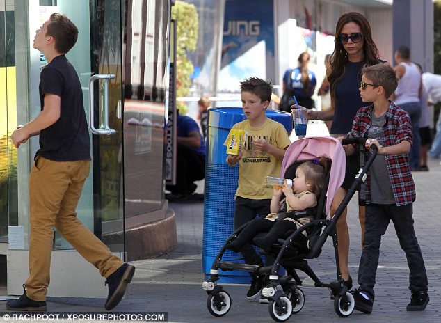 Family fun: Victoria looked stylish in a two-tone shift dress while the male members of the clan dressed casually